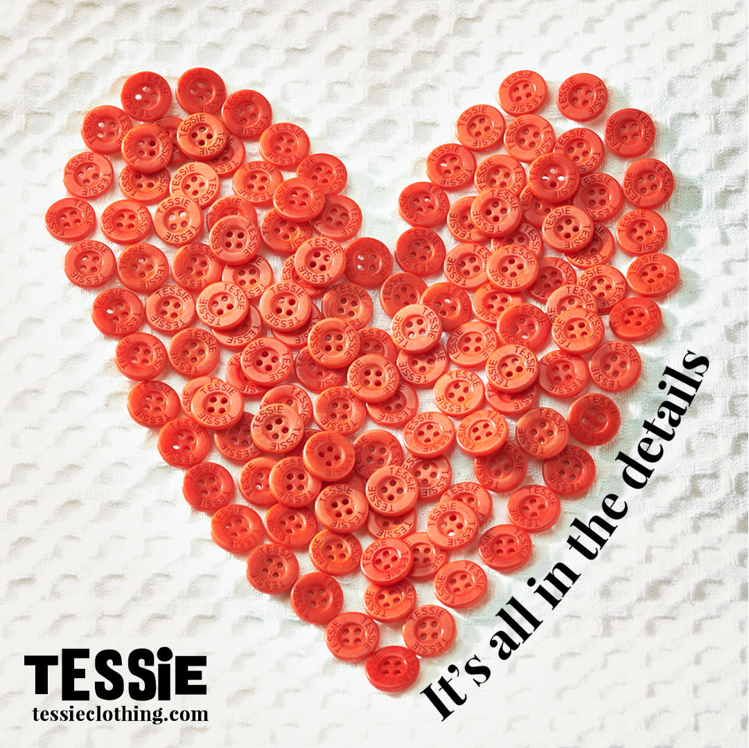 Tessie Clothing Red corozo branded buttons in the shape of a heart.